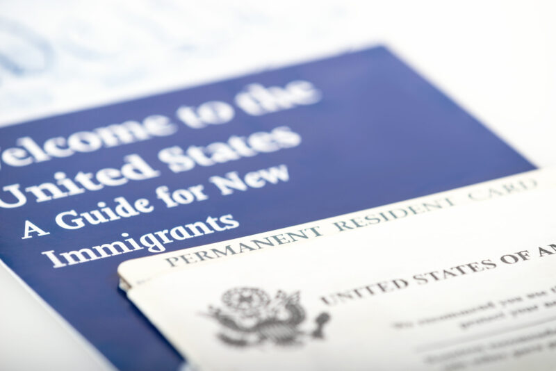 United States of America permanent resident card, green card. Immigration concept. Closeup with shallow depth of field.