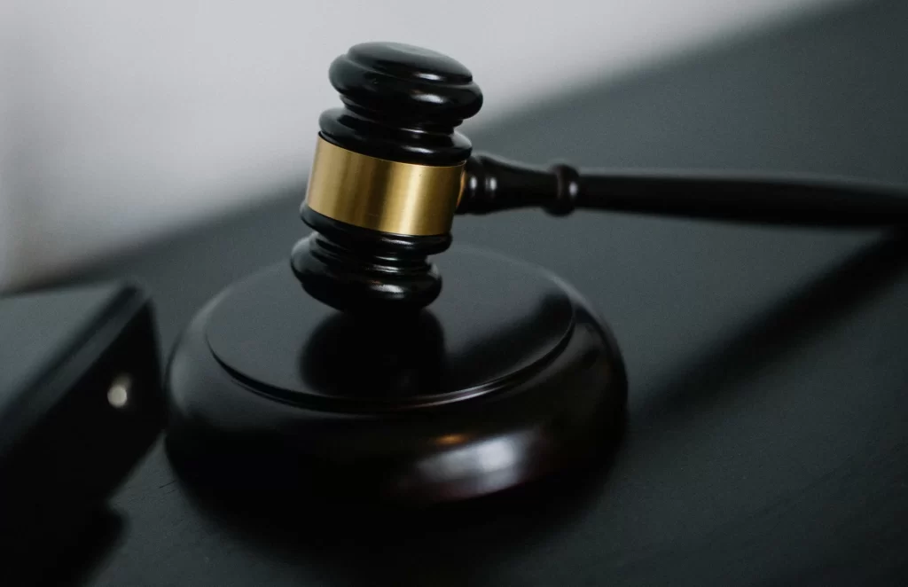 Close-up of a black wooden gavel with a gold band resting on a desk, symbolizing law and justice.
